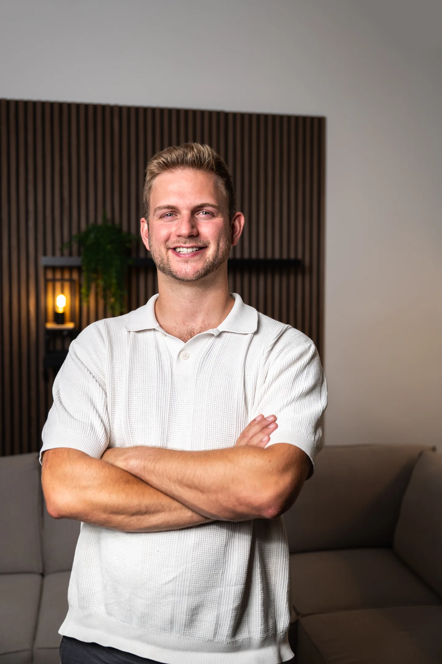 Marco steht lächelnd mit verschränkten Armen im Synclaro-Büro