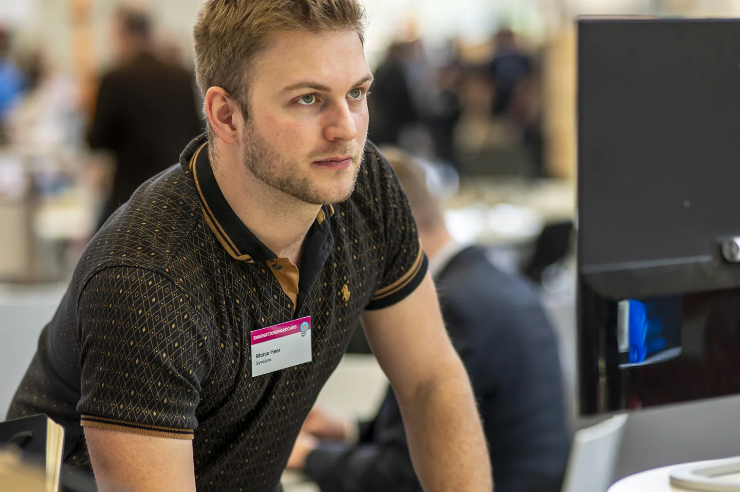 Marco hört am Messestand aufmerksam zu